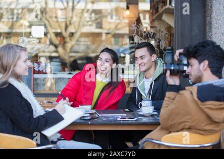 Junge Freunde hängen aus und studieren im Straßencafé Stockfoto