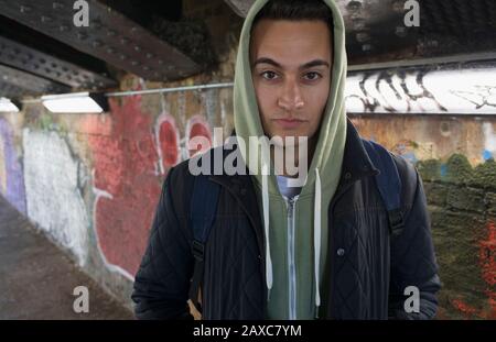 Portrait seriöser, zäher junger Mann, der im städtischen Tunnel hoody trägt Stockfoto