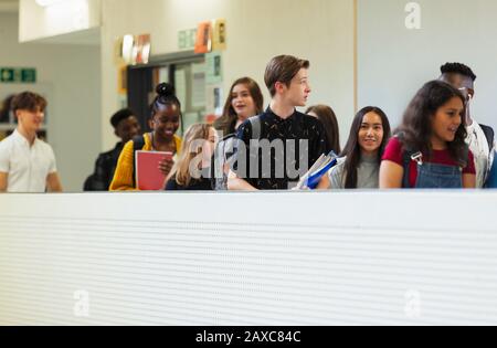 Junge Studenten, die auf dem Korridor spazieren gehen Stockfoto