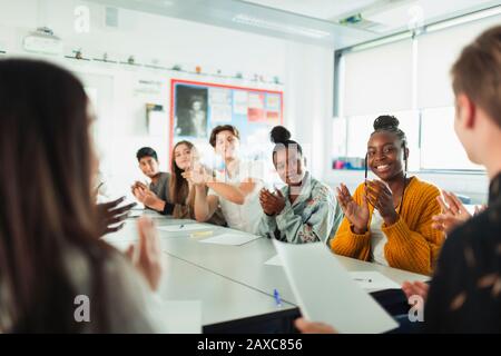 Fröhliche High-School-Schüler klatschen in der Debattierklasse Stockfoto