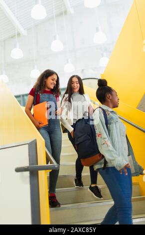 Schüler der jungen hohen Mädchen, die Treppen hinabsteigen Stockfoto