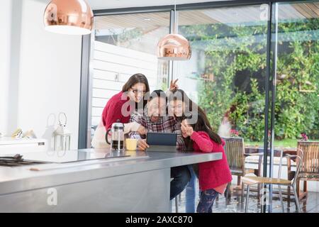 Verspielte Familie, die selfie mit digitalem Tablet in der Morgenküche mitnimmt Stockfoto