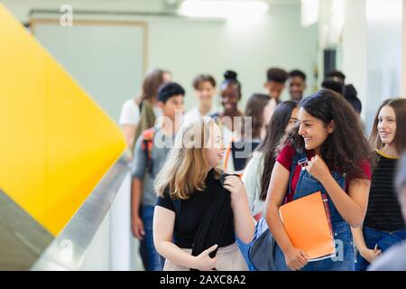 Schüler der jungen hohen Mädchen, die auf dem Flur spazieren Stockfoto