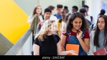 Schüler der jungen High Girl, die auf dem Flur spazieren und sprechen Stockfoto