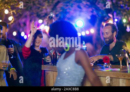 Freunde tanzen und trinken auf der Gartenparty Stockfoto