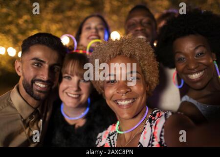 Portrait fröhliche Freunde, die auf der Party Neon tragen Stockfoto