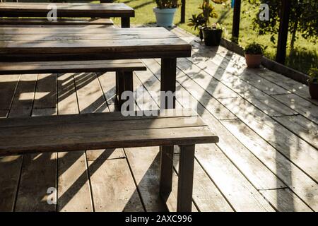 Pavillon in einem Straßencafé mit Pflanzen, Holztischen, Bänken und Blumen Stockfoto