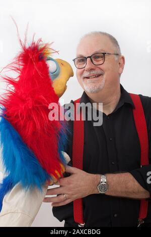 Ein Ventriloquist mit Papagei am Arm Stockfoto