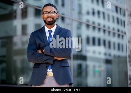 Portrait afroamerikanischer Unternehmer mit Kopienfläche im städtischen Gebäude, mit Erfolg lächelnd, möglicher CEO, Geschäftsführer Stockfoto