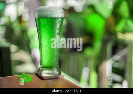 Bei der Feier des St. Patrick's Day steht in einem Pub ein Glas Grünbier auf dem Tisch. Grünes Bier - ein Symbol für das fest des Heiligen Patrick Tages. Stockfoto