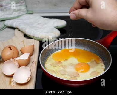 Beim Frittieren in einer Pfanne Rührei salzen Stockfoto