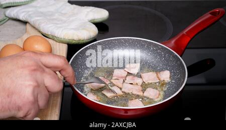 Vor dem Zugabe von Eiern Schinken in einer Pfanne braten Stockfoto