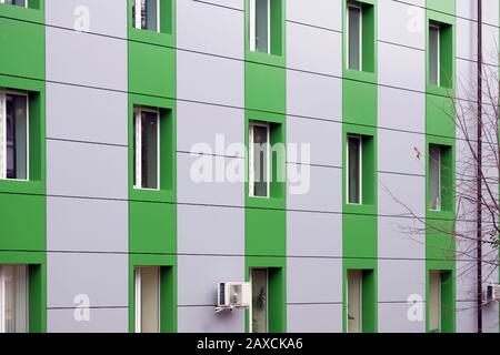 Dekorative Fassade des Hauses. Paneel in Grau und Grün für die Wand eines mehrstöckigen Gebäudes. Wand eines Mehrfamilienhauses mit Windo Stockfoto