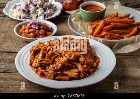 Veganer Grillplatz. Gebackene Bohnen im Südstaaten-Stil, Coleslaw, Brötchen zum Abendessen und Pommes frites. Stockfoto