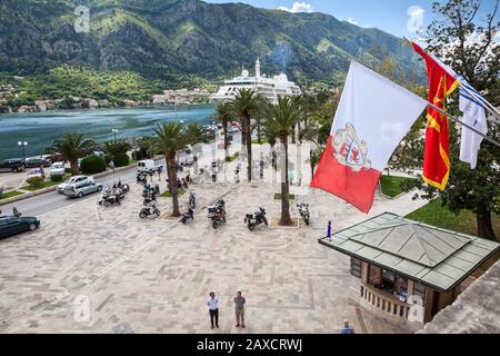 Kotor, MONTENEGRO - CIRCA Jun, 2016: Montenegrinische Nationalflaggen winken an der Wand der Altstadt. Der zentrale Platz und der Hafen liegen am Ufer der Bucht von Kotor (Boka K Stockfoto