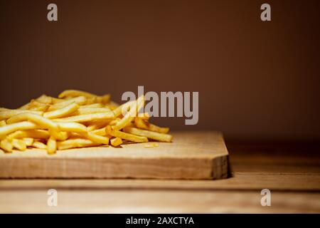 Pommes frites auf einem Holztisch. Food, Junk Food und Fast-Food-Konzept Stockfoto