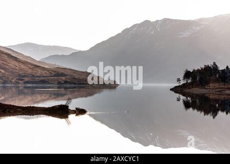 Schneebedeckte Berge und Hügel spiegeln sich in Loch Cluanie, Glen Sheil, Scottish Highlands wider Stockfoto