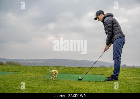 Golfer auf einem grünen Spielfeld, der Golfball streitet Stockfoto