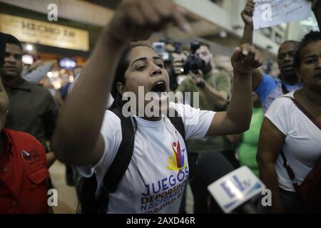 11. Februar 2020, Venezuela, Caracas: Anhänger der venezolanischen Regierung rufen politische Slogans gegen die Opposition ab, während sie auf die Ankunft des Oppositionsführers Guaido am Flughafen warten. Nach einer etwa dreiwöchigen Auslandsreise soll der selbsternannte interimspräsident Guaido in Caracas landen. US-Präsident Trump hat dem Oppositionsführer während seiner Auslandsreise weitere Unterstützung versprochen. Anhänger der venezolanischen Regierung sehen ihn als "Verräter". Foto: Rafael Hernandez / dpa Stockfoto