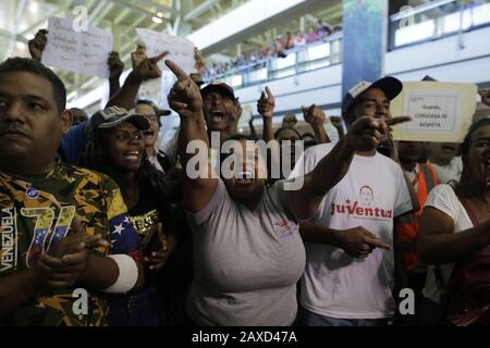 11. Februar 2020, Venezuela, Caracas: Anhänger der venezolanischen Regierung rufen politische Slogans gegen die Opposition ab, während sie auf die Ankunft des Oppositionsführers Guaido am Flughafen warten. Nach einer etwa dreiwöchigen Auslandsreise soll der selbsternannte interimspräsident Guaido in Caracas landen. US-Präsident Trump hat dem Oppositionsführer während seiner Auslandsreise weitere Unterstützung versprochen. Anhänger der venezolanischen Regierung sehen ihn als "Verräter". Foto: Rafael Hernandez / dpa Stockfoto