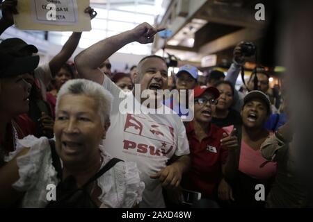 11. Februar 2020, Venezuela, Caracas: Anhänger der venezolanischen Regierung rufen politische Slogans gegen die Opposition ab, während sie auf die Ankunft des Oppositionsführers Guaido am Flughafen warten. Nach einer etwa dreiwöchigen Auslandsreise soll der selbsternannte interimspräsident Guaido in Caracas landen. US-Präsident Trump hat dem Oppositionsführer während seiner Auslandsreise weitere Unterstützung versprochen. Anhänger der venezolanischen Regierung sehen ihn als "Verräter". Foto: Rafael Hernandez / dpa Stockfoto