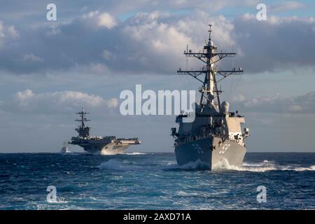 Ein nuklear angetriebener Flugzeugträger der Nimitz-Klasse der US-Marine, USS Theodore Roosevelt, Arleigh-Burke-Klasse, die Geleitflugkörperzerstörer USS Russell und USS Pinckney transits den Pazifischen Ozean 3. Dezember 2019 im Pazifischen Ozean. Stockfoto