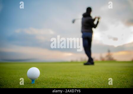 Golfer auf einem grünen Spielfeld, der Golfball streitet Stockfoto