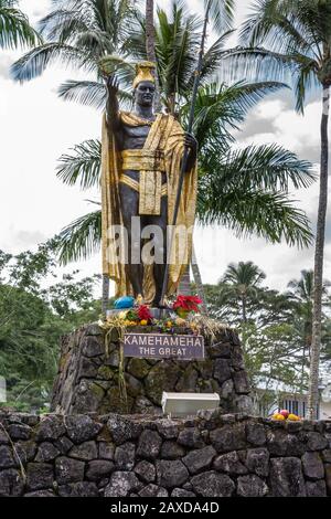 Hilo, Hawaii, USA. - 9. Januar 2012: Nahaufnahme der Statue von König Kamehameha, dekoriert mit goldener Amdkrone und langem Speer unter weißem Wolkenkratzen Stockfoto