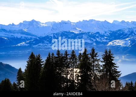 Panaramische Skyline Blick auf schneebedeckte Berge, die über den nebligen Vierwaldstattersee, den Luzerner See, die Schweiz, unvornehmlich überragen. Stockfoto