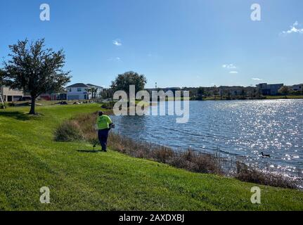 Orlando, FL/USA-2/10/20: Ein geschwungener Gehweg neben einem See, der ein Fußweg in Hinterhäusern im Laureate Park Lake Nona an Orlando, Florida neigh ist Stockfoto