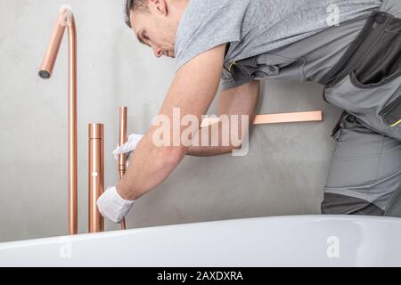 Moderne und Stilvolle Badewannen Installation Inklusive Elegantem Besatz. Hauptverbesserung Thema. Kaukasier Installateur in Seinen 30er Jahren. Stockfoto