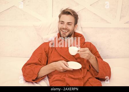 Ab Tag mit guten Kaffee. Entspannt zu Hause. Angenehme Momente. Gourmet Espresso. Kaffee am Morgen genießen. Gerne morgen. Schöner Mann trinken Kaffee am Morgen. Happy bärtiger Mann im Bett. Gute Laune. Stockfoto
