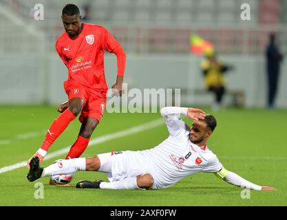 Doha, Katar. Februar 2020. Almoez Ali (L) von Duhail SC Vies mit Ahmad Noorollahi vom Persepolis FC während des Fußballspiels der AFC Champions League Gruppe C zwischen Katars Duhail SC und dem iranischen Persepolis FC in Doha, Katar, 11. Februar 2020. Kredit: Nikku/Xinhua/Alamy Live News Stockfoto