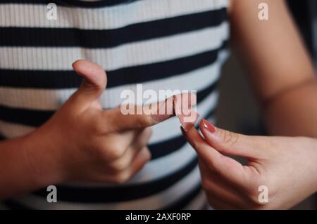 Mädchen erste Hilfe Fingerverletzung durch sich Stockfoto