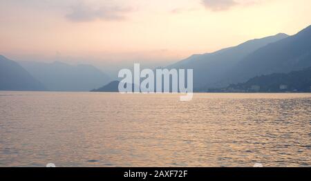 Duskblick auf den Comer See, die Lombardei Italien, über das Wasser des schönen Sees, die Dörfer, die Wolke verhüllte Berge und die dramatische Landschaft Stockfoto