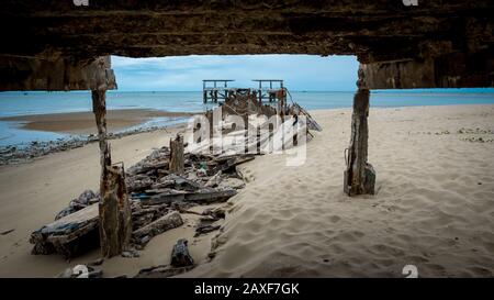 Verfallene alte Fischerstation bricht in das Meer ein, das von der Anlegestelle in Pak Nam Pran am Golf von Thailand in Thailand eingerahmt wird Stockfoto