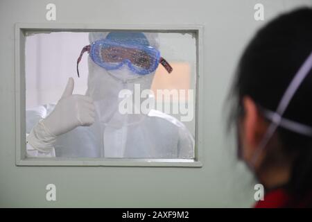 Peking, Chinas Hunan-Provinz. Februar 2020. Die Krankenschwester Yi Junfeng (L) gibt einen unterstützenden Daumen für einen unter Quarantäne gestellten Patienten in einer Fieberklinik des Hunan People's Hospital in Changsha, der zentralen chinesischen Provinz Hunan, 7. Februar 2020. Credit: Chen Zeguo/Xinhua/Alamy Live News Stockfoto