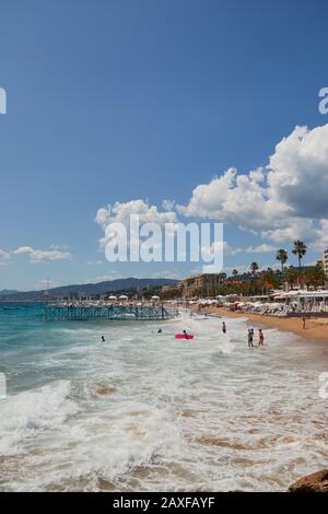 Cannes, FRANKREICH - 06. Juni 2019: Schöner vertikaler Schuss vom Strand von Cannes an einem sonnigen Juni Tag mit einem fast klaren Himmel mit Menschen, die das genießen Stockfoto