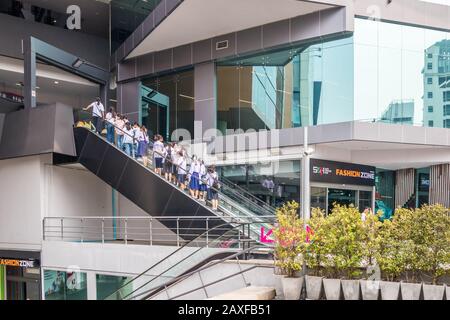Bangkok, Thailand - 10. Januar 2020: Schulkinder, die eine Rolltreppe zum Siam Square One hinauf gehen. Dies ist ein Einkaufszentrum Stockfoto