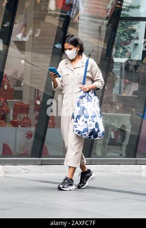 Bangkok, Thailand - 10. Januar 2020: Frau mit Gesichtsmaske zum Schutz vor Smog und Coronavirus. Die Stadt wurde von Smog in geplagt Stockfoto