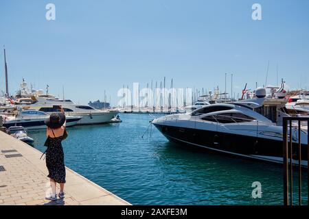 Cannes, FRANKREICH - 06. Juni 2019: Schöne junge Frau, die vor Luxusbooten und Yachten in cannes frankreich ein selfie an einem Dock nimmt. Stockfoto