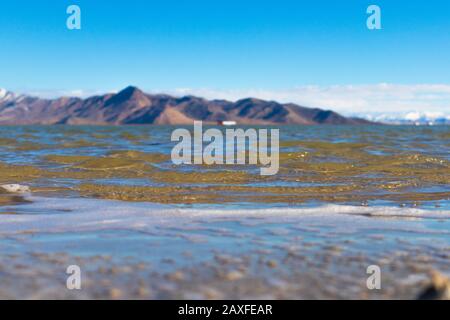 Blick über das Wasser auf die Berge Stockfoto