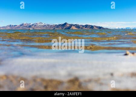 Blick über das Wasser auf die Berge Stockfoto