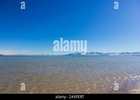 Blick über das Wasser auf die Berge Stockfoto