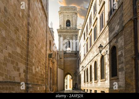 Die enge alte Gasse, die zu einer bogenförmigen Tür des Glockenturms führt, außerhalb des Doms von Brindisi, Italien, in der Region Apulien. Stockfoto