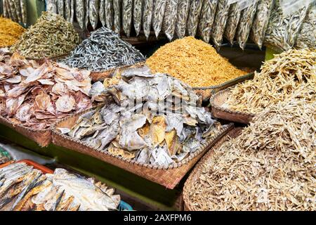 Nahaufnahme von Haufen getrockneter und gesalzter kleiner Fische in Bambuskörben auf dem Central Wet Market in Iloilo, einer lokalen Delikatesse auf den Philippinen, Asien Stockfoto