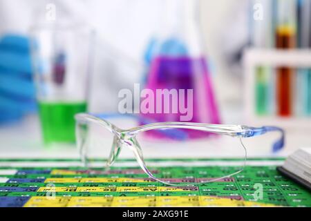 Schützende chirurgische oder Lab Gläser liegen auf periodische Tabelle Stockfoto