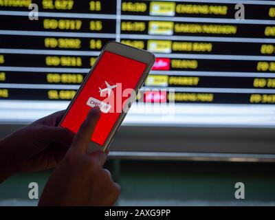 Flugcheck per Handy. Berühren Sie auf dem Smartphone-Bildschirm, um sich vor dem Hintergrund der Flugplaninformationen für einen Flug einzuchecken Stockfoto