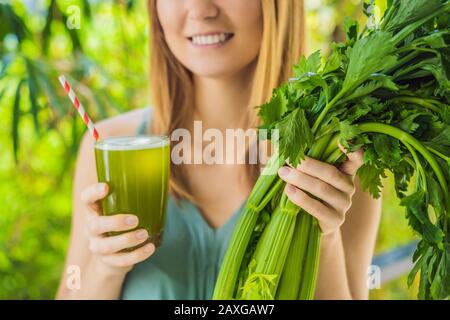 Junge Frau trinkt auf Holzgrund Celery-Saft, Gesundes Getränk, Sellerie Stockfoto