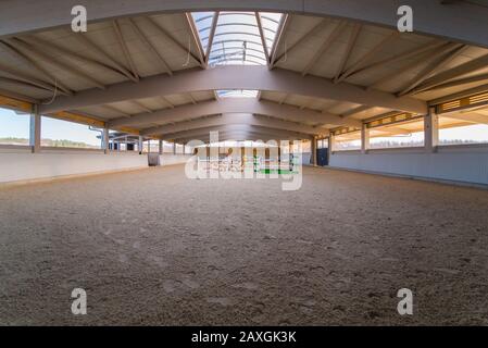 Eine aufwendige Dachkonstruktion bedeckt eine neu erbaute, mit Sandboden gefüllte Riesen-Reitarena Stockfoto